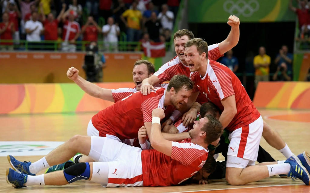 Dänische Handballspieler jubeln nach einem Sieg auf dem Spielfeld